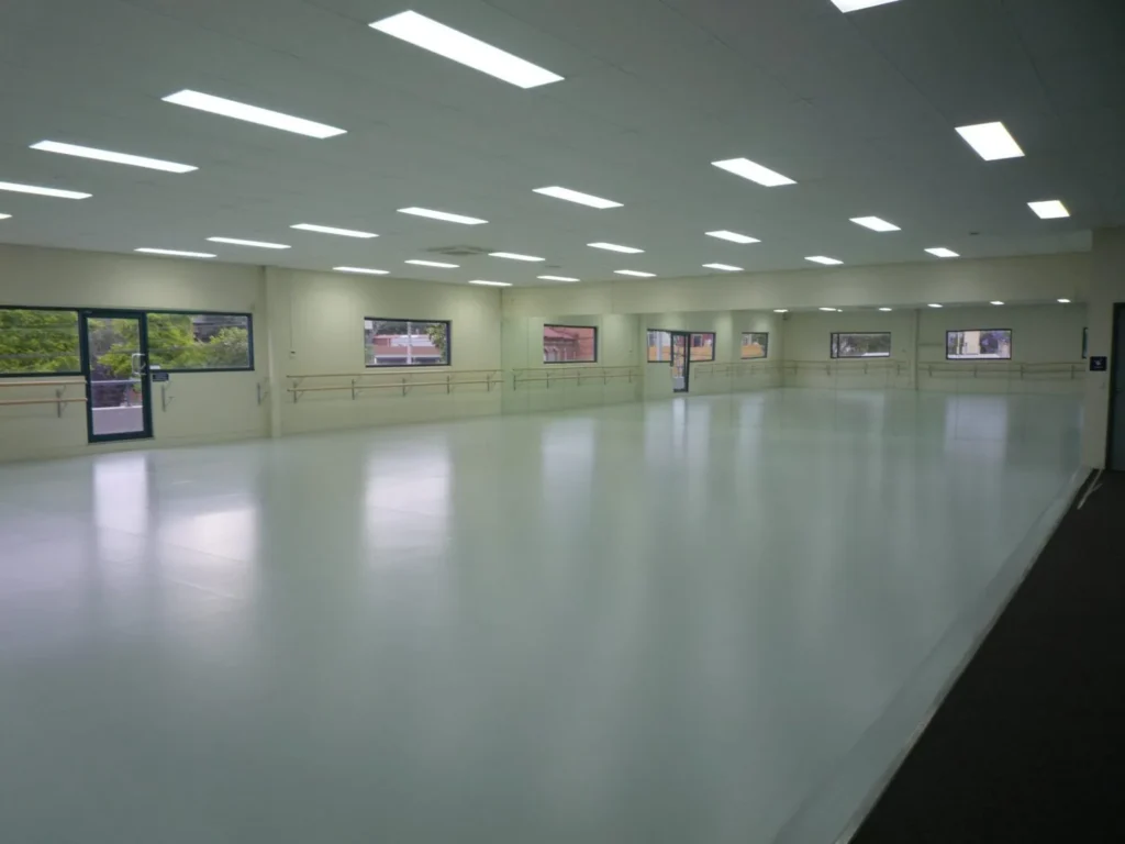 Large dance studio fitted out by STM with grey vinyl floor, mirrors and barres