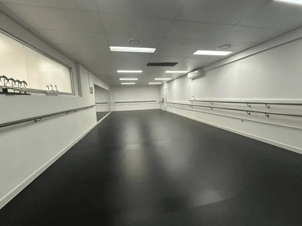 Dance studio fitted with STM dance barres, grey dance vinyl and white drapes