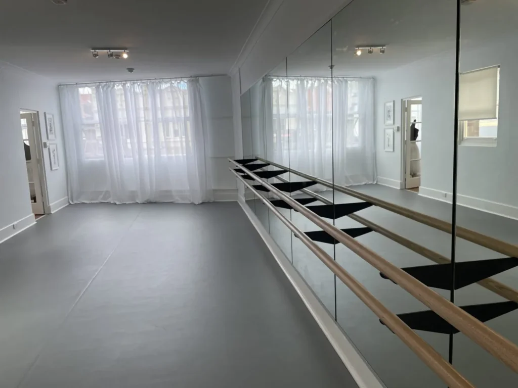 Double timber dance barre mounted through a mirror wall on STM mirror wall brackets