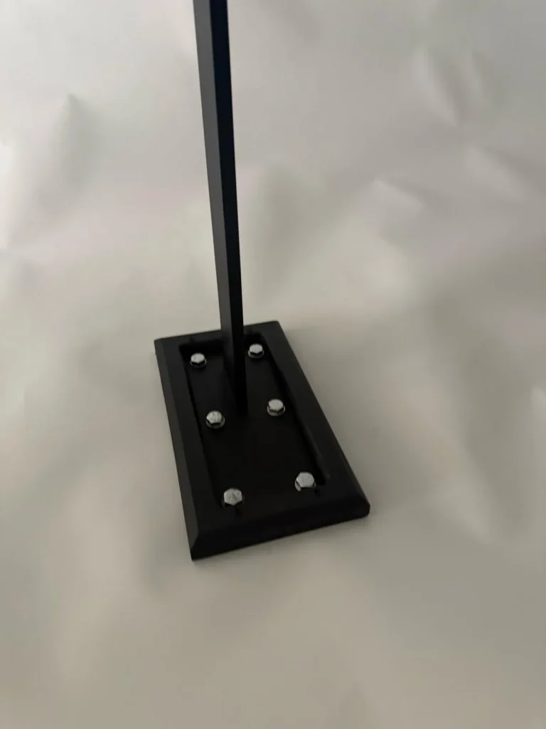 Black cover plate concealing the floor bolts of an STM barre stanchion