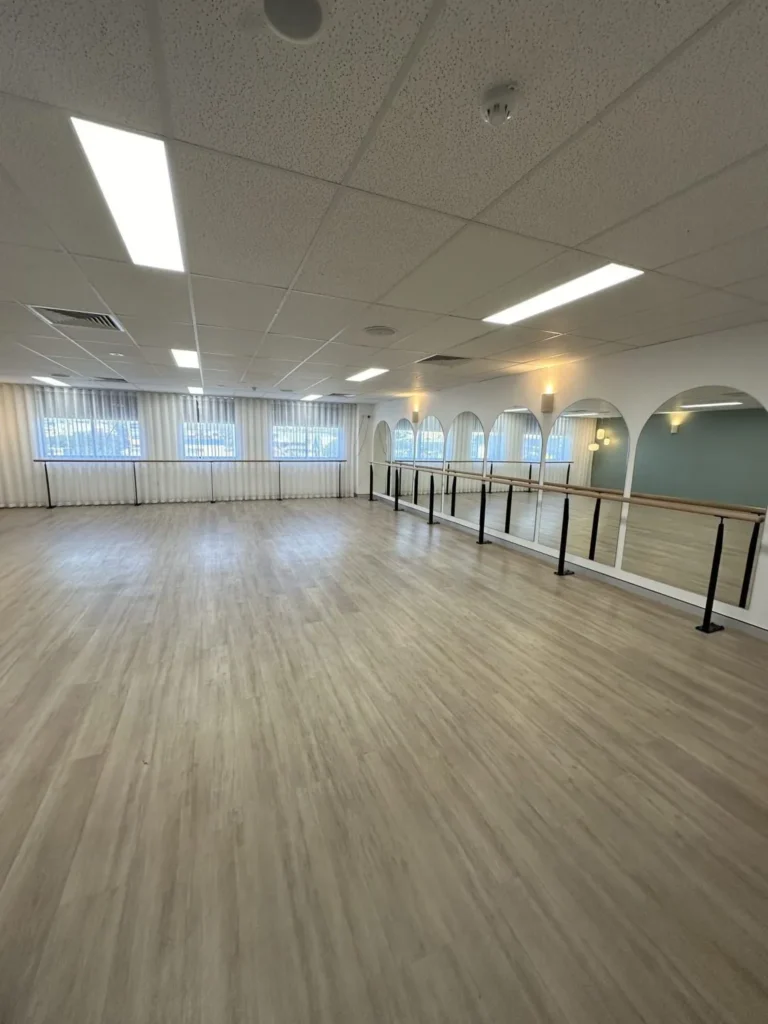 Wall-fixed STM Pilates barre brackets and timber barre in a bright Pilates studio